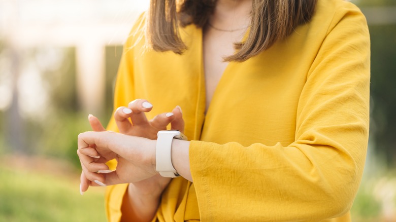 A woman looks at her smartwatch