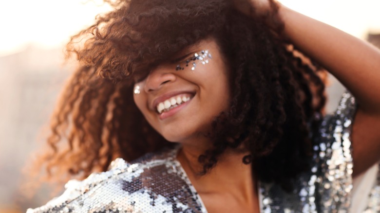 woman wears matching eye glitter and sequined top 