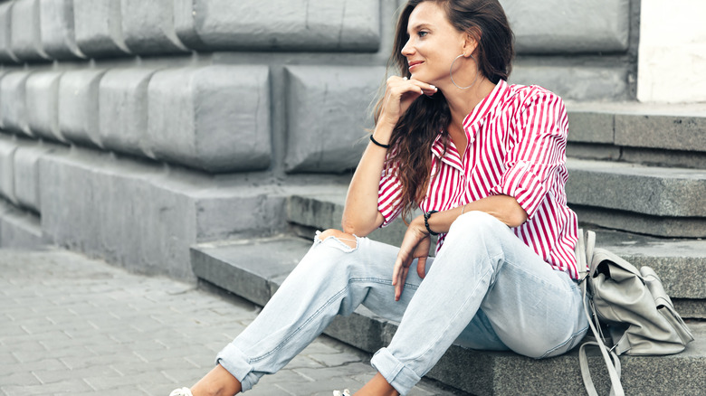 A woman wearing ripped jeans and a striped shirt