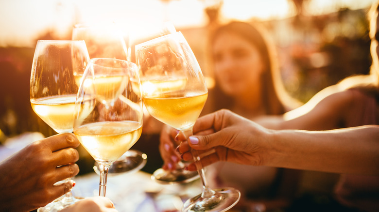 Friends clinking glasses of wine together 