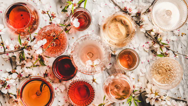 Glasses of wine on a table surrounded by flowers 