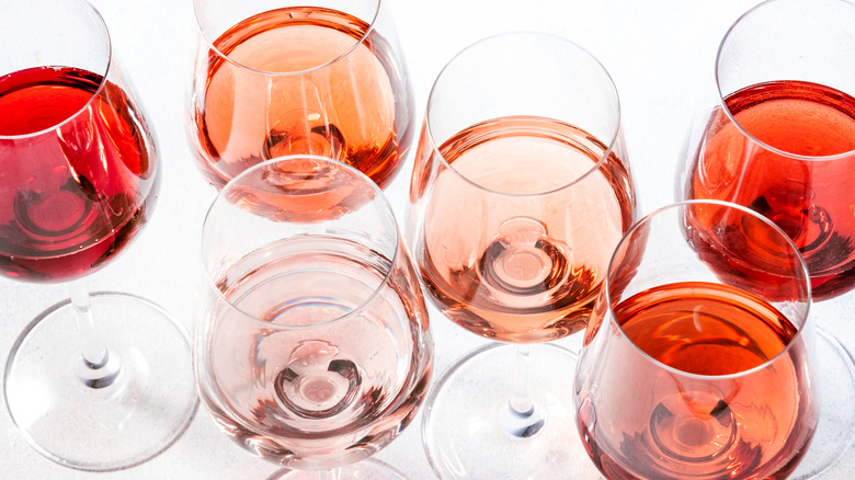 Wine glasses filled with multiple pink and red wines