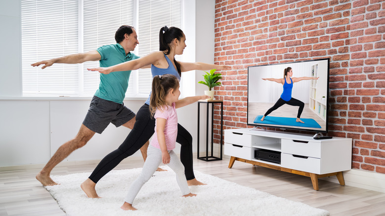 Family doing yoga together in living room