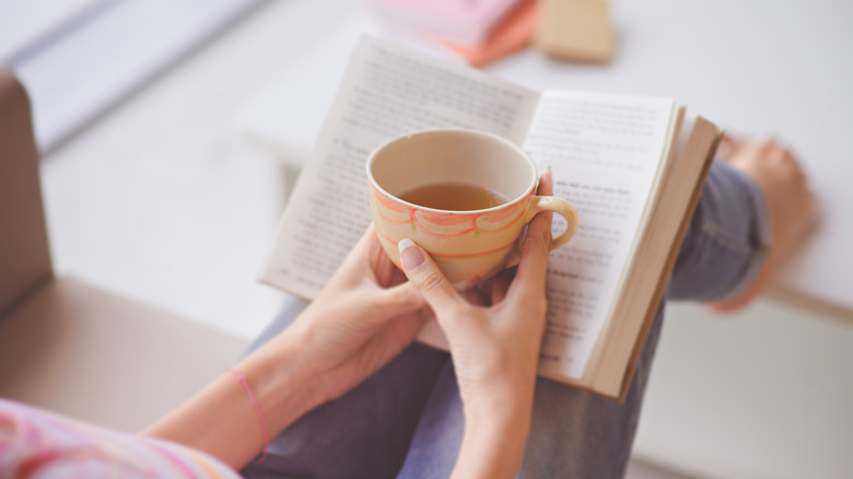 A woman reading with a cup of coffee 