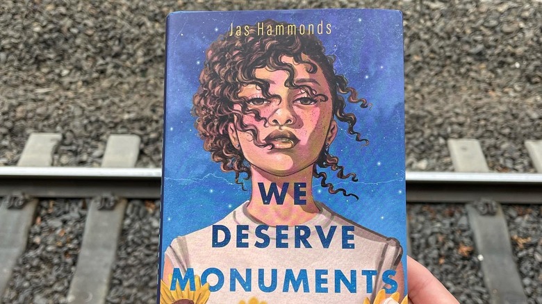 Jas Hammonds' "We Deserve Monuments" held over railroad tracks