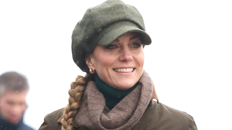 Princess Catherine smiling in a green hat with her hair in a side braid