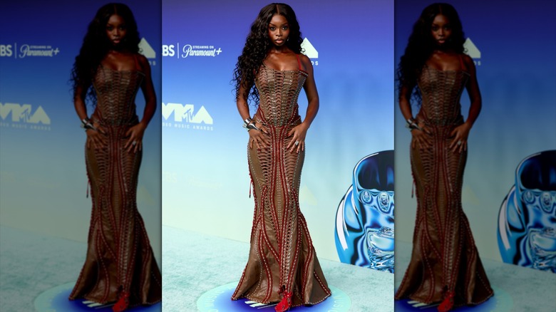 Olandria Carthen posing in a brown leather, lace-up dress