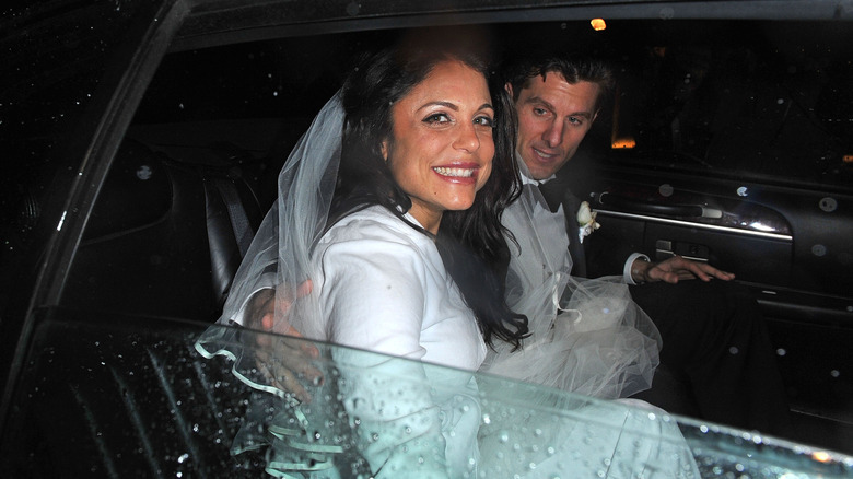 Bethenny Frankel holding hands with Jason Hoppy courtside