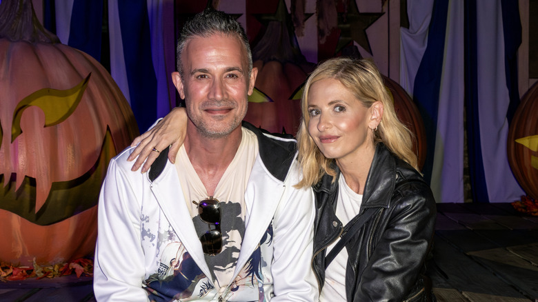 Sarah Michelle Gellar and Freddie Prinze Jr. sitting amid Halloween decor