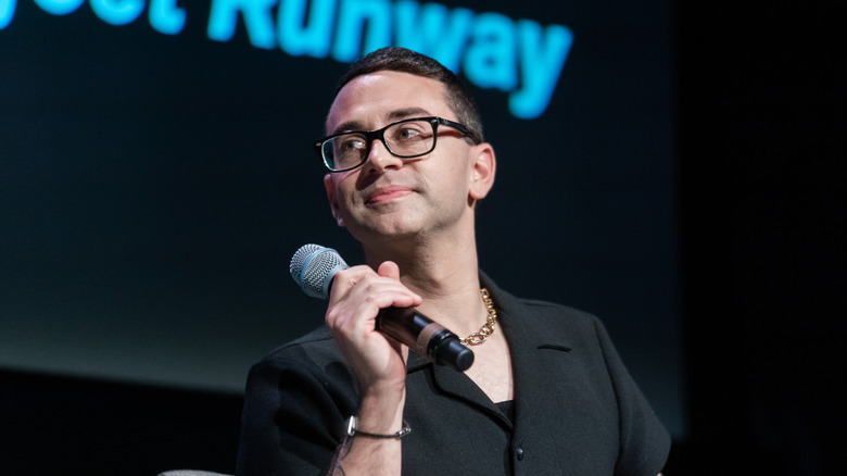 Christian Siriano holding a microphone while speaking at an event about Project Runway