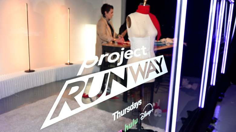 A design cubicle with the Project Runway logo printed against the glass in front of a mannequin