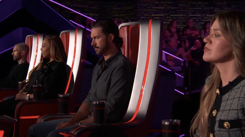 The coaches on "The Voice" listening to a contestant, all straight faced.
