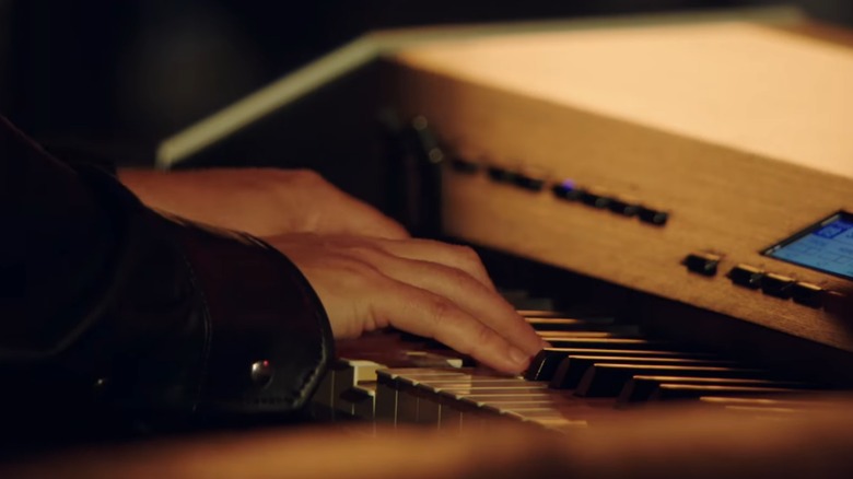 A "The Voice" band member playing the keyboard during a performance on the show.