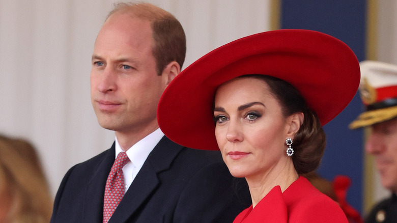 Princess Catherine in red hat beside Prince William