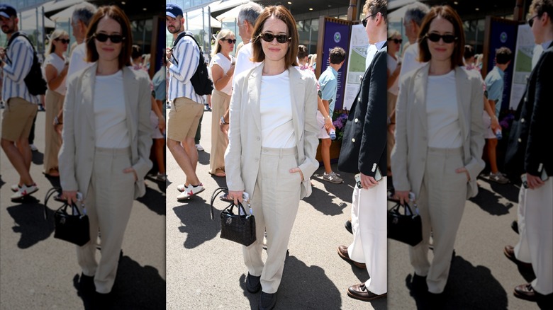 Claire Foy smiles with one hand tucked into her pants' pocket