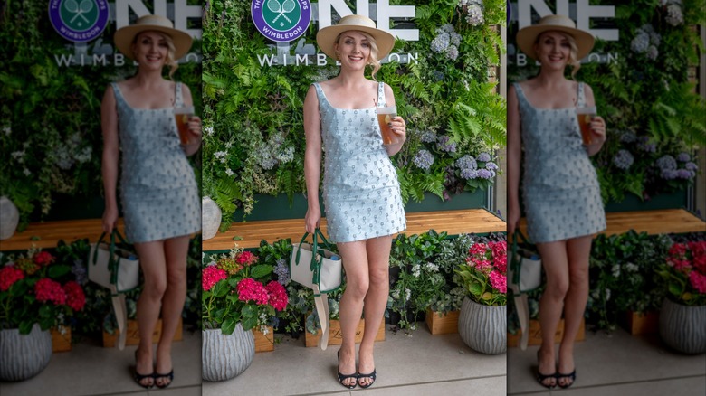 Evanna Lynch smiles with a drink in hand at Wimbledon