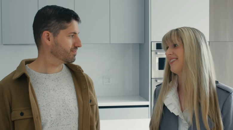 A blonde homeowner smiles at her partner in a renovated kitchen on Love It or List It.