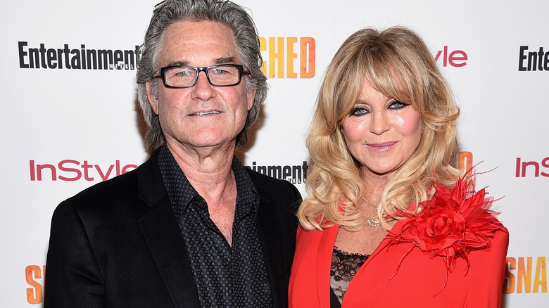 Goldie Hawn with Kurt Russell in front of white background.