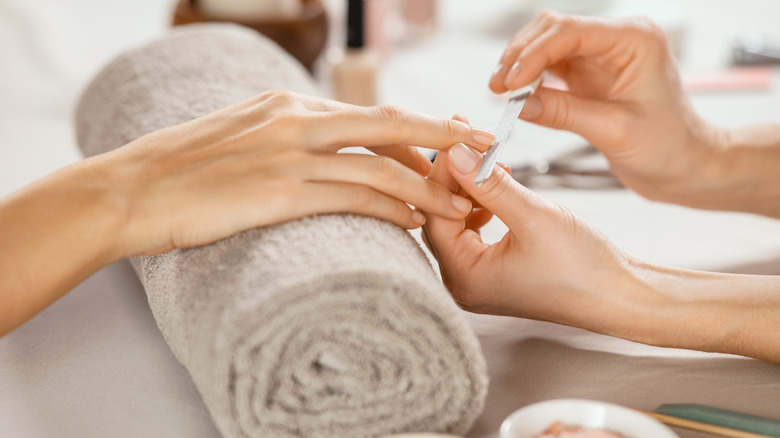 Woman gets her nails filed