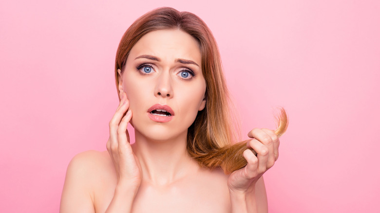 Woman holding her over processed hair