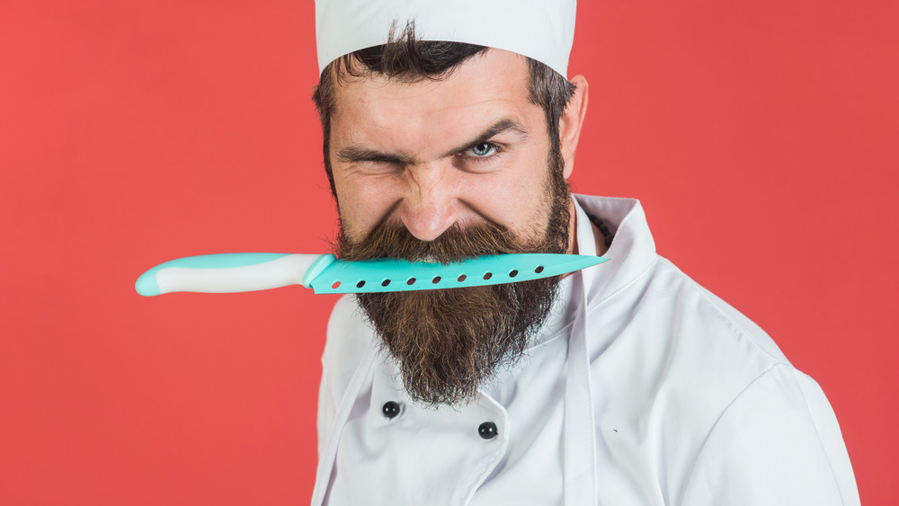 Chef holding knife in teeth