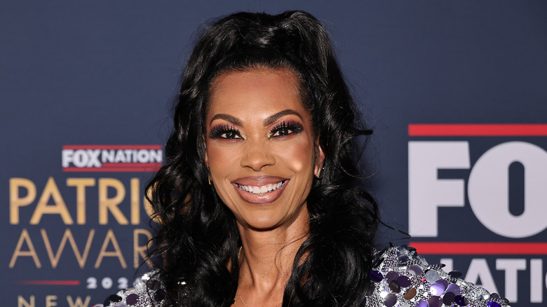 Closeup of Harris Faulkner smiling on step-and-repeat wearing heavy makeup