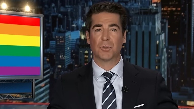 Jesse Watters reporting beside a pride flag graphic on his Fox News show "Jesse Watters Primetime"