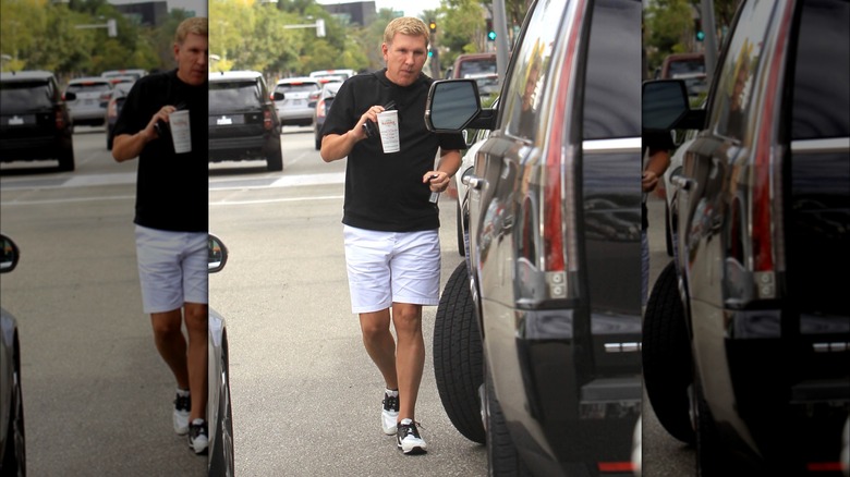 Todd Chrisley walking down the street with a drink