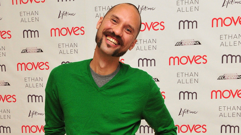 Andrae Gonzalo in green smiling at an event