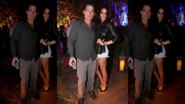 Thomas Ravenel in black shirt and gray pants holding drink with Rouge Apker
