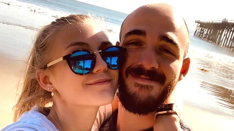 Gabby Petito in sunglasses on beach with Brian Laundrie