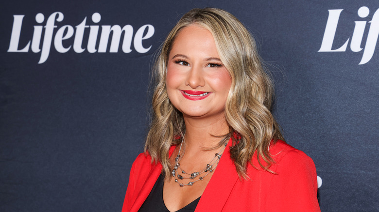 Gypsy Rose in red blazer and black shirt smiling at a Lifetime event