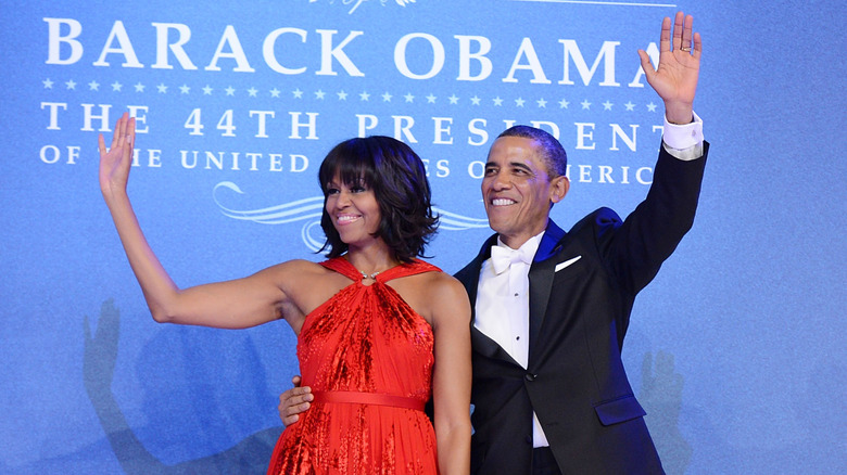 Michelle and Barack Obama smiling and waving