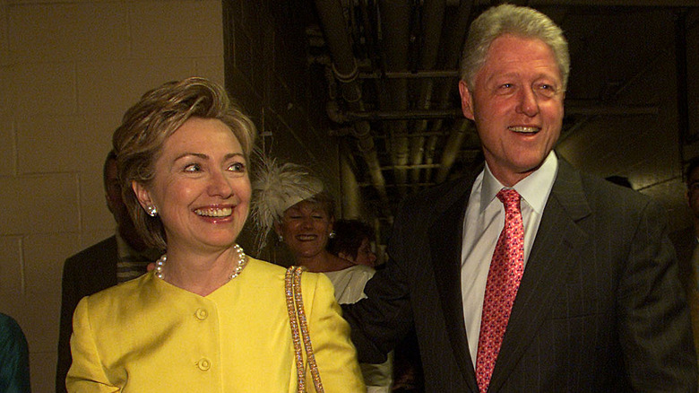 Hillary Clinton and Bill Clinton smiling while walking together