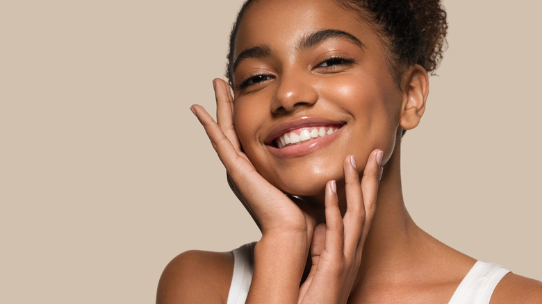 Black woman smiling with her hand on her face