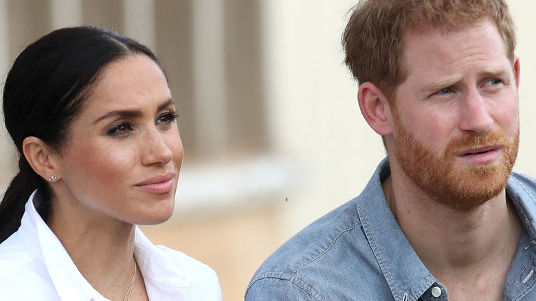 Meghan and Harry listen during an interview