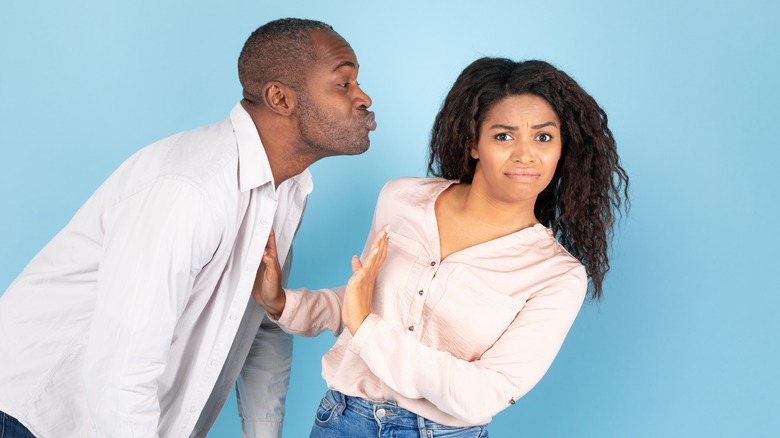 Woman rejecting a kiss from man