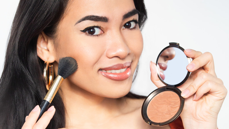 A woman applying bronzer