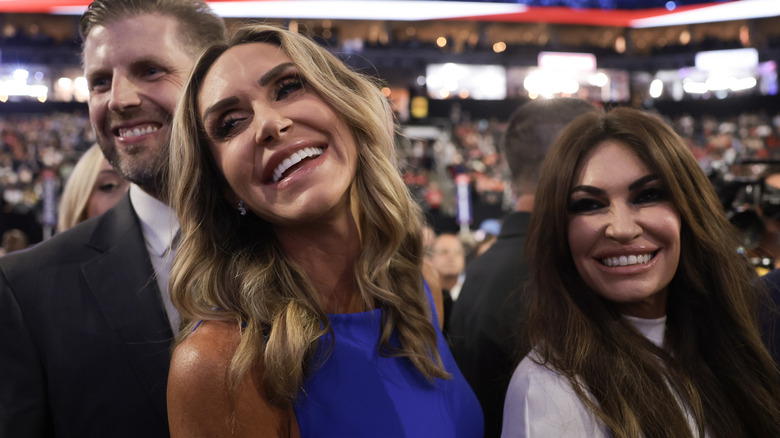 Eric Trump, Lara Trump, and Kimberly Guilfoyle beaming at a Trump event