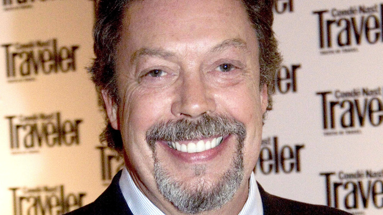 Tim Curry smiles on the red carpet