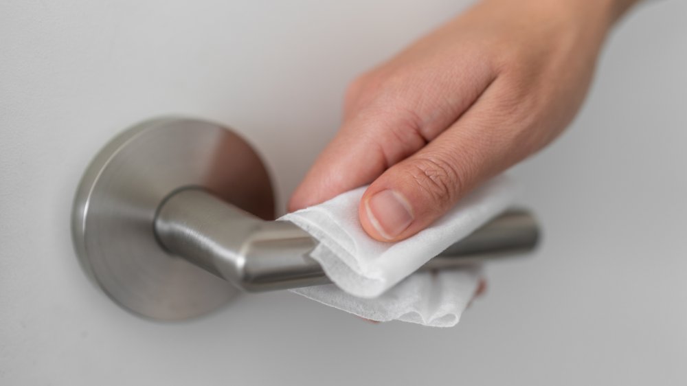 Opening a door handle with tissue to prevent contact