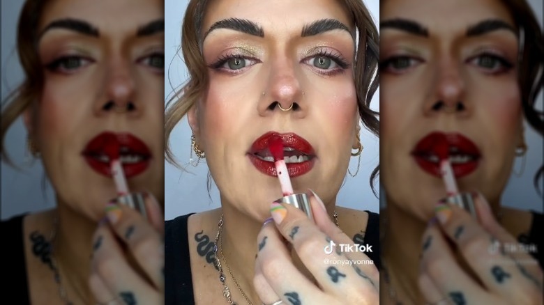 Woman applying red lip gloss