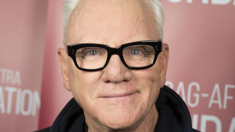 Malcolm McDowell smiling in glasses