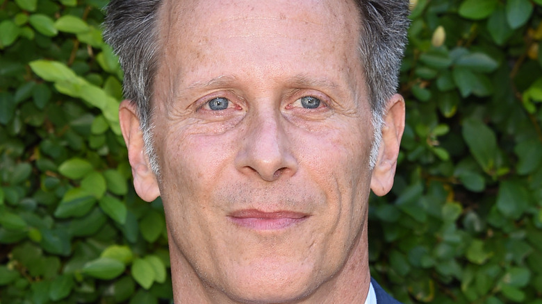 Steven Weber posing in front of foliage