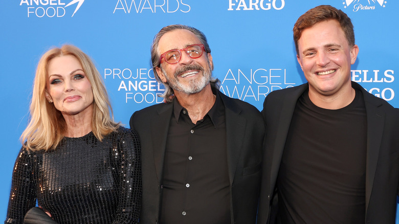 Belinda Carlisle matching in black with husband Morgan Mason and James Duke Mason