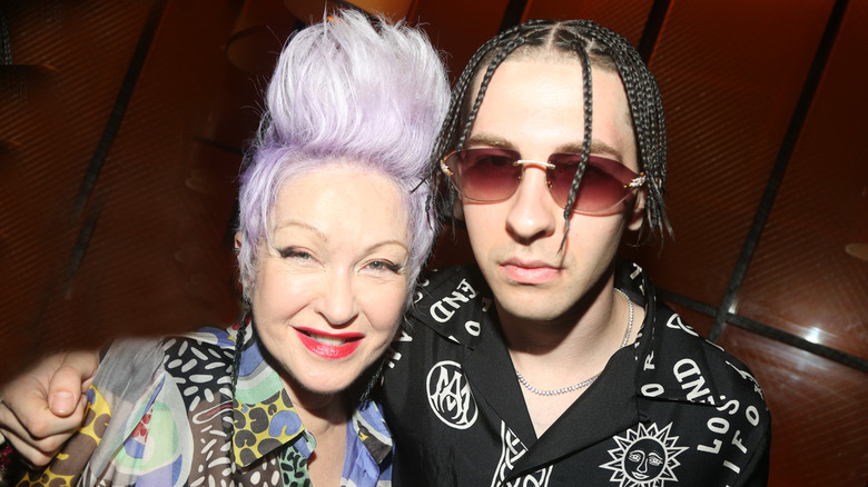 Cyndi Lauper with short purple hair beside her son Declyn Lauper