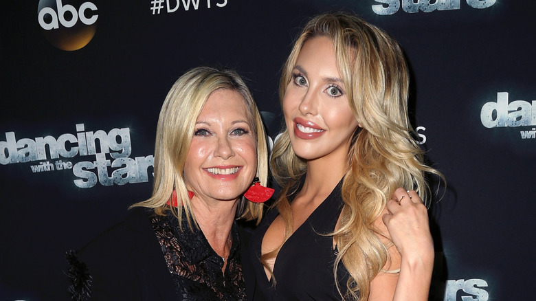 Olivia Newton-John in red earrings beside daughter Chloe Rose Lattanzi
