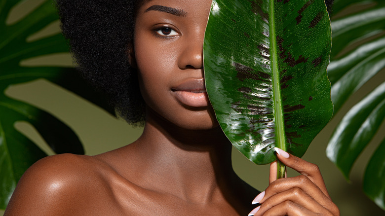 woman posing with large leaf