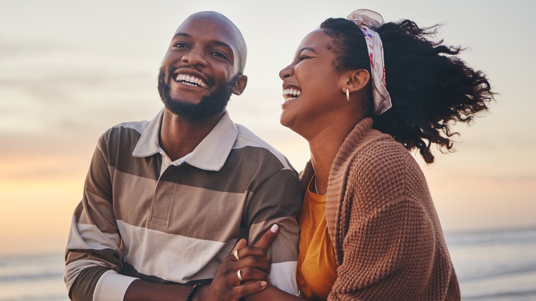 couple walking on beach laughing