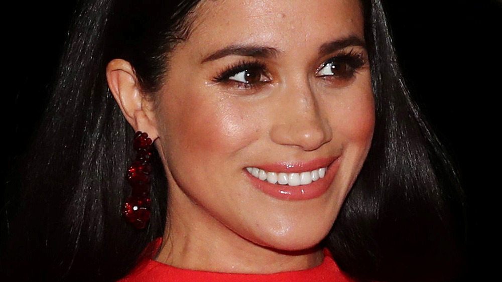 Meghan Markle smiling in red